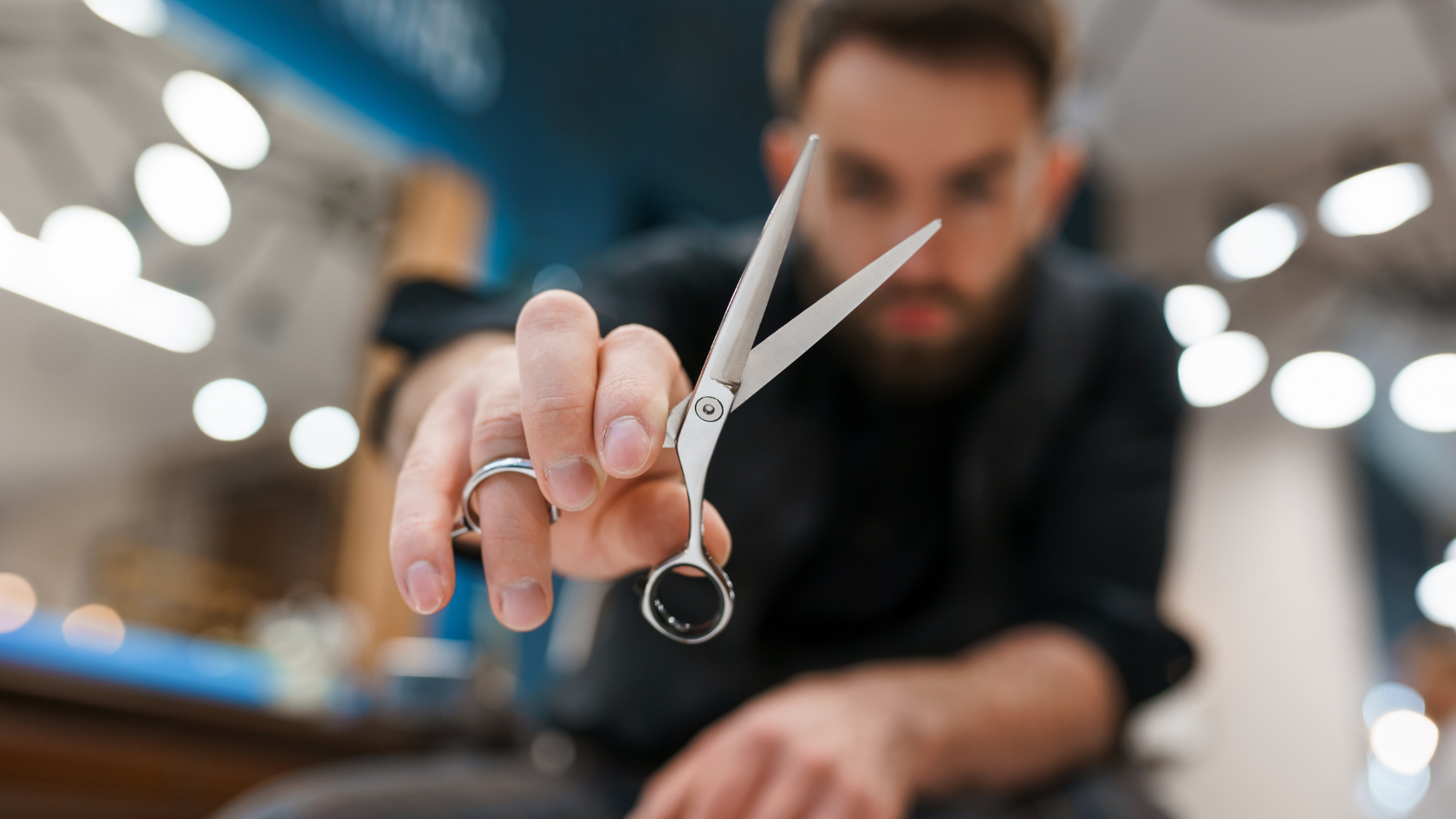 A man holding a pair of scissors in his hand